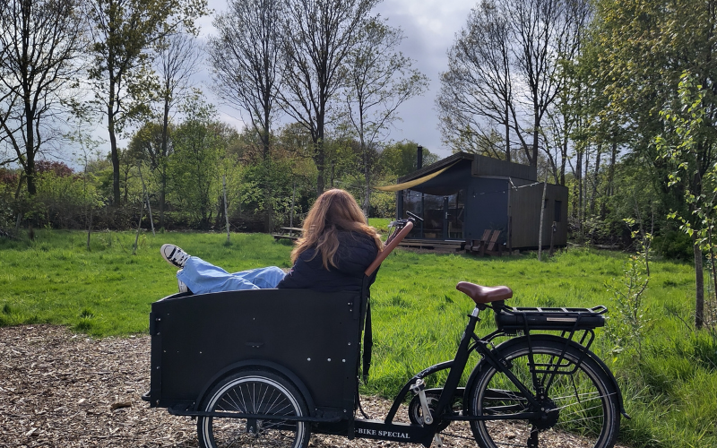 Meisje in bakfiets bij tiny house met hottub